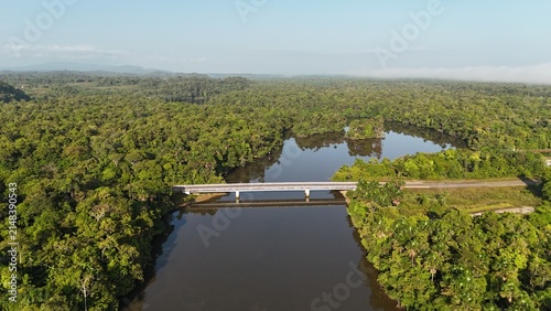 Photography Aerial view of the La Comté River bridge surrounded by tropical rainforest in French Guiana