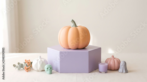 Pastel purple hexagon podium decorated with pastel pumpkins and tiny skull on white background