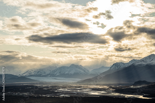 Alaskan mountains in sunrise over snow-capped peaks, glacier, and valley in autumn