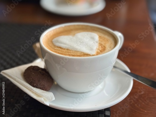 Obraz na płótnie Close up of Hot cappuccino with heart shaped latte art foam served on saucer wit