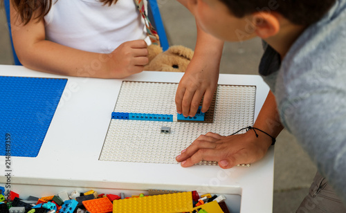 Robotics instructor demonstrates building techniques to a young student during a beginner STEM workshop, encouraging practical learning, creativity and problem-solving.