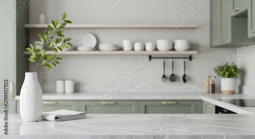 White marble countertop with vase and plant in a green kitchen interior with blurred background