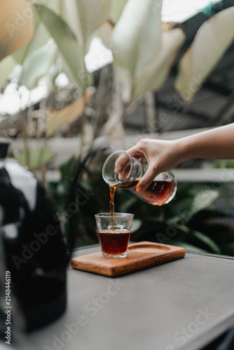 фотографія Pouring Fresh Espresso into Glass Cup During Specialty Coffee Brewing Process