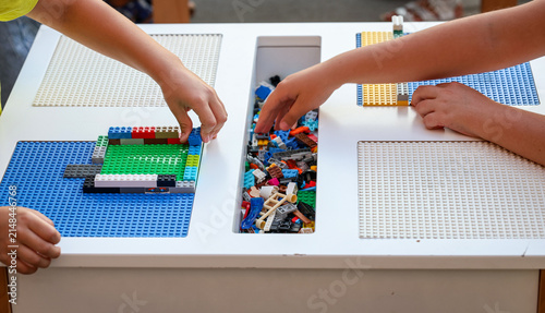 Children build colorful structures with construction blocks during a beginner STEM and robotics workshop, developing teamwork, creativity and problem-solving skills