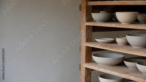 Simple and Elegant Wooden Shelf Displaying Various Clay Bowls and Plate Designs