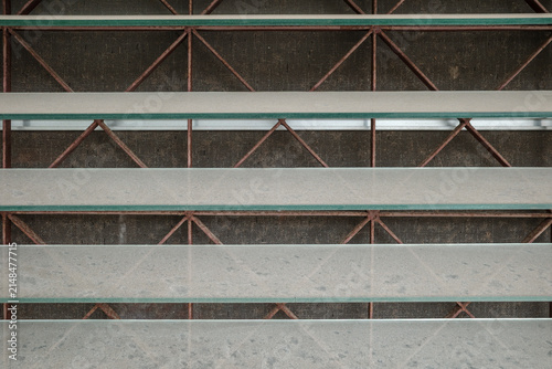 Obraz na plátně A close-up view of glass shelves layered louver in front of a rusty metal structural framework and mesh screen indoors during the day