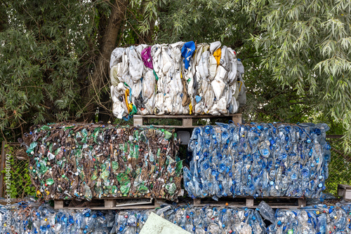 Bild auf Leinwand Compressed plastic bottles sorted by color and stacked in bales for recycling
