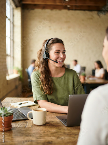 Customer support woman with headset in loft office