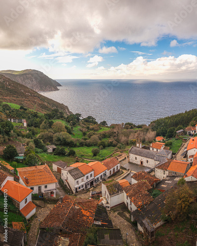 Aerial view of the historic Santo Andre de Teixido sanctuary and village with orange-tiled rooftops by the Atlantic Ocean Santo Andre de Teixido, A Coruna, Spain.