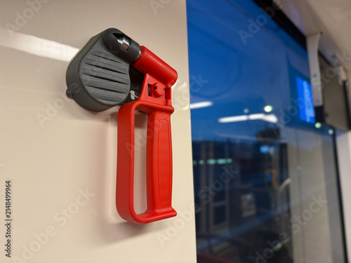 Emergency glass breaker beside a tram window at night