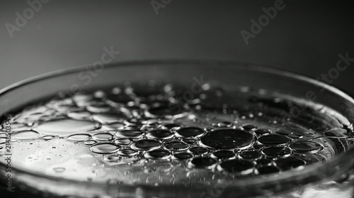 Oil bubbles in a glass dish in dramatic monochrome light
