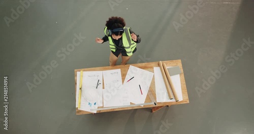 Construction, dance or engineer with headphones, music playlist or playful groove on building site. Space, above or woman with upbeat movement, fun time or radio streaming in development project.