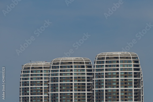 Obraz na plátně A trio of modern residential and office buildings in a deep blue sky