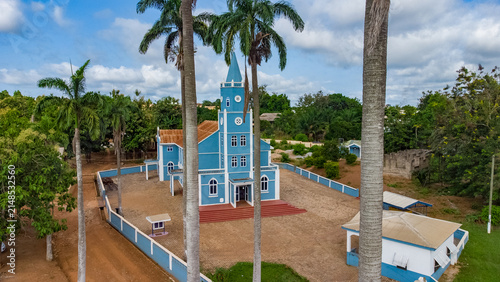 Aerial view of the Presbyterian Church Of Ghana - Bethel Congregation Konongo with its distinctive blue facade, surrounded by tall palm trees and a paved courtyard in Konongo, Ashanti Region, Ghana.