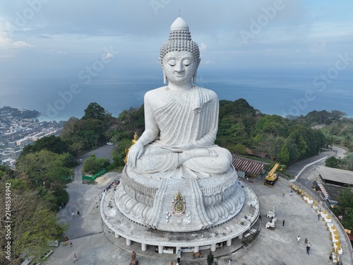 Aerial view of Big Buddha Phuket, a large white marble statue overlooking the coastline with lush green hills and the sea in the background Karon, Phuket, Thailand.