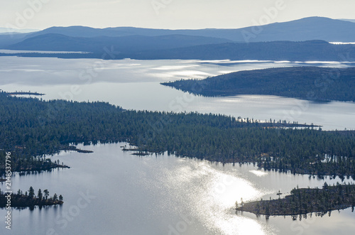 Aerial view of Rogen nature reserve featuring expansive lakes, dense coniferous forests, and scattered islands under soft sunlight in Tannas, Jamtland County, Sweden.