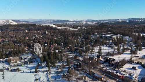Aerial view of Zakopane in the Tatra Mountains, Poland, with snow-covered chalets, pine forests and roads under a clear blue winter sky in Lesser Poland Voivodeship.