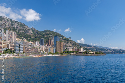View of the coastal skyline of Monaco City featuring modern high-rise buildings set against the mountains and the Mediterranean Sea in Monaco City, Monaco.