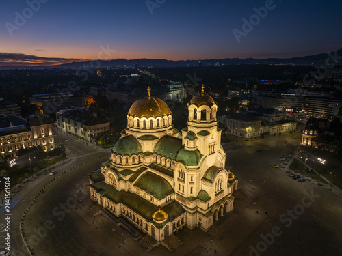 Aerial view of Patriarchal Cathedral St. Alexander Nevsky illuminated at twilight with golden domes and green roofs in Sofia, Sofia City Province, Bulgaria.