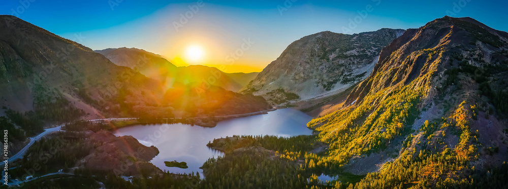 Fototapeta premium Golden sunrise glows over Ellery Lake mountains