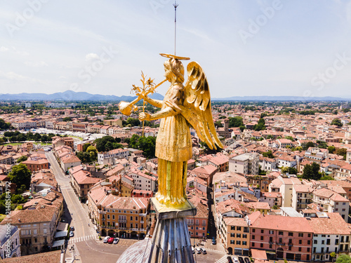 Aerial view of the golden angel statue atop the dome of the Basilica of St. Anthony overlooking the historic rooftops and streets of Padua, Veneto, Italy.