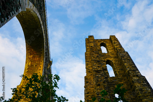 The historic Moorswater Viaduct near Liskeard, Cornwall, spans a deep valley with eight striking semi-circular arches built from snecked rock-faced slatestone and granite. 