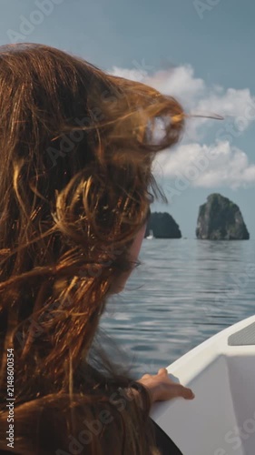 Red-haired woman enjoys a peaceful boat ride with a view of tropical islands in el nido, philippines