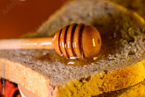 Konstfotografi Golden honey and fresh bread slices beside glass jar in warm rustic kitchen sett