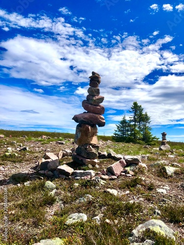 Stone cairn balance balance on mountain trail under blue sky, summer at Sälen city Sweden.