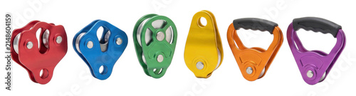 Colorful collection of climbing rope pulleys and rescue gear in various designs, including single and double sheave models, arranged in a neat horizontal row for comparison