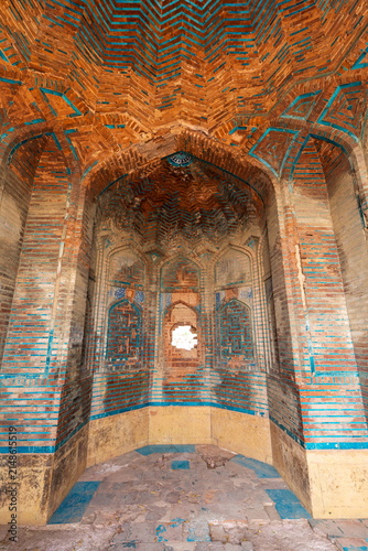 View of the intricate brickwork and blue glazed tile patterns inside a historic tomb at the Makli Necropolis in Thatta, Sindh, Pakistan.