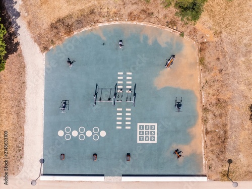 Aerial view of an outdoor fitness area with exercise equipment and painted markings on a rubberized surface in Estoril, Lisbon, Portugal.