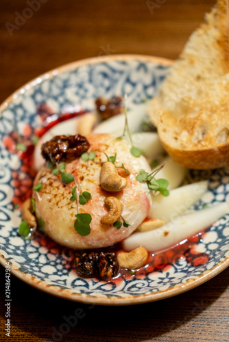 Baked soft cheese with pear, nuts, berry sauce and toasted bread