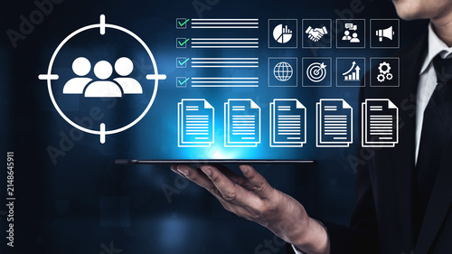 Fotografía A businessman holds a tablet showcasing various analytics and target audience visuals, symbolizing data-driven decision-making in a modern corporate landscape