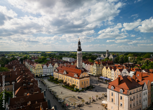 Boleslawiec, Poland - 11 May 2025: Aerial view of the historic town hall and market square surrounded by colorful tenement houses with red-tiled roofs under a blue sky.