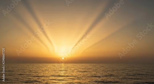 A radiant sunrise over ocean, with sun rays piercing the sky