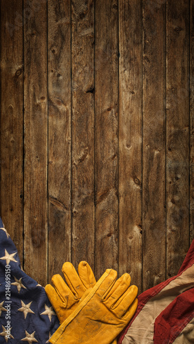 Work gloves with the American flag on wooden background. Symbolic of blue collar workers, USA manufacturing, pride in products Made in United States of America, or for Father's day or US Labor Day.