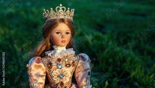 Young princess portrait in ornate gown with crown outdoors.