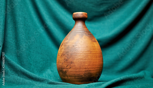 Handmade Terracotta Pot Vase Against Teal Backdrop.