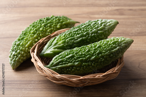 Bild auf Leinwand Fresh bitter gourd or bitter melon in a basket on a wooden background, Asian veg