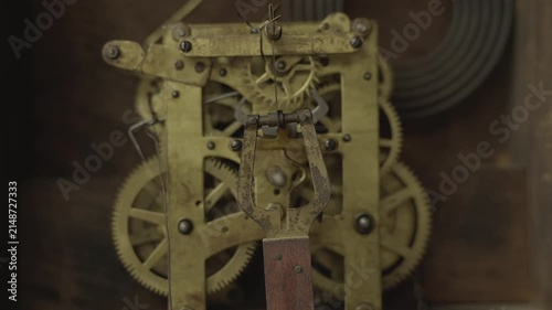 Conceptual shot of distorted, warped mechanical clock gears and a swinging pendulum representing abstract time, memory loss, aging, or a dream state.