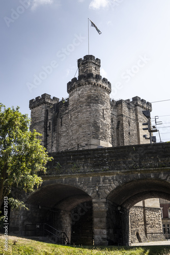 View of the historic Newcastle Castle Keep featuring stone battlements and arched masonry under a clear blue sky in Newcastle upon Tyne, England, United Kingdom.