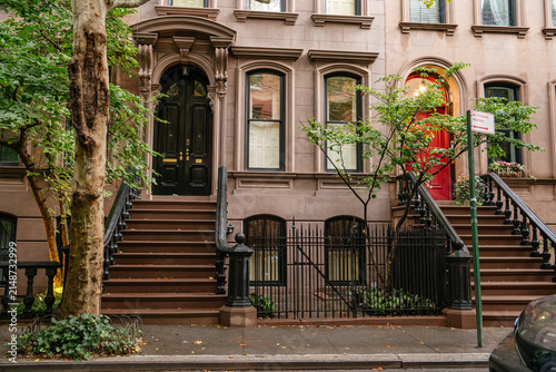 Fotografie Historic New York brownstone townhouses featuring classic stoop staircases, black and red wooden doors, and decorative iron railings
