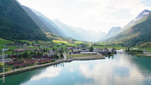 Aerial view of the village of Olden nestled between steep mountains and the turquoise waters of the Nordfjord in Olden, Vestland, Norway.