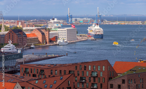 Elevated view of Copenhagen harbor with cruise ships, boats, waterfront buildings and port infrastructure in Denmark.