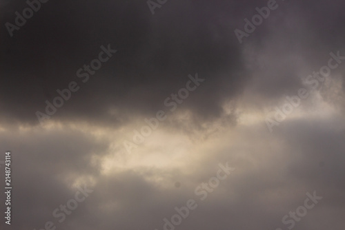 Foto Dramatic storm clouds with golden light, dark overcast sky before rain, moody at