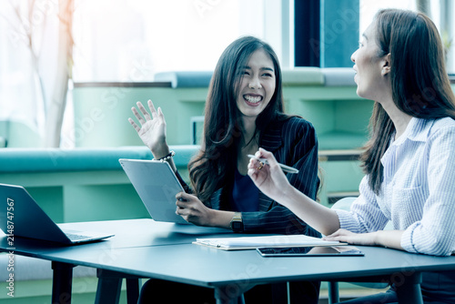 A group of Gen Z Asian business consulting, exchanging information in offices, co-working spaces.