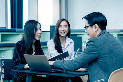 A group of Gen Z Asian business consulting, exchanging information in offices, co-working spaces.