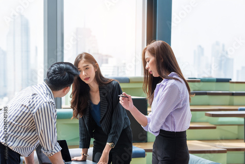 A group of Gen Z Asian business consulting, exchanging information in offices, co-working spaces.