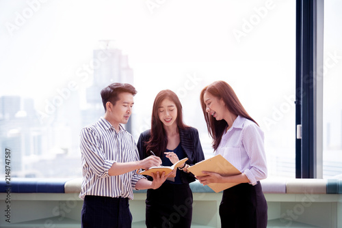 A group of Gen Z Asian business consulting, exchanging information in offices, co-working spaces.